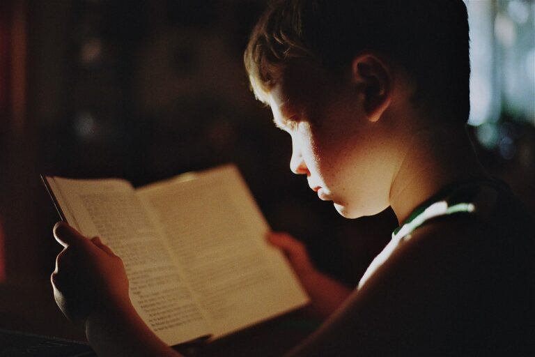 Enfant écoutant une histoire de dragon pour enfant, livre ouvert sur les genoux